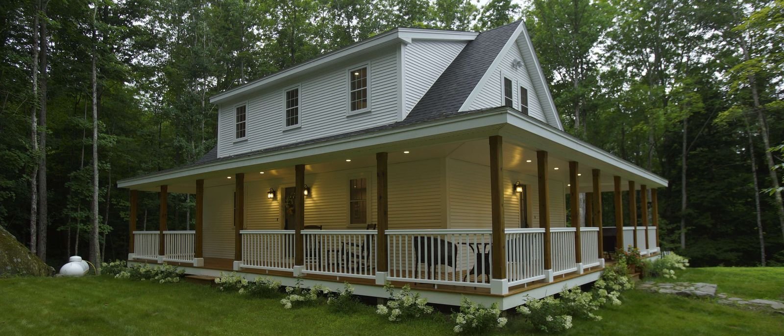 Exterior custom home build with wrap-around porch and recessed lighting