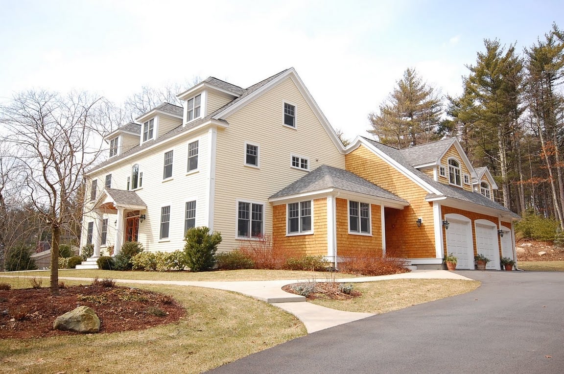 Exterior of a two-story home with attached garage, landscaped yard, and driveway in the Coastal New Hampshire area Exterior of a two-story home with attached garage, landscaped yard, and driveway in the Coastal New Hampshire area