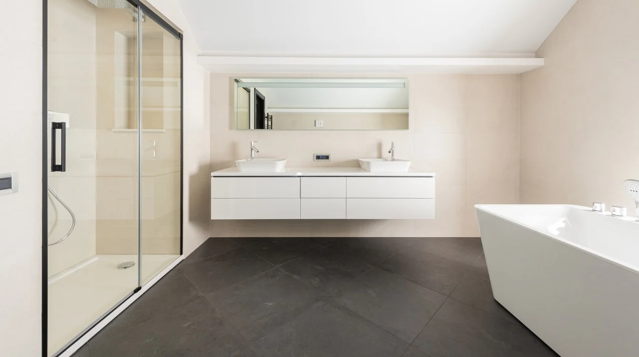 Modern bathroom in Coastal NH with glass walk-in shower, freestanding tub, double vanity, and sleek minimalist design-1