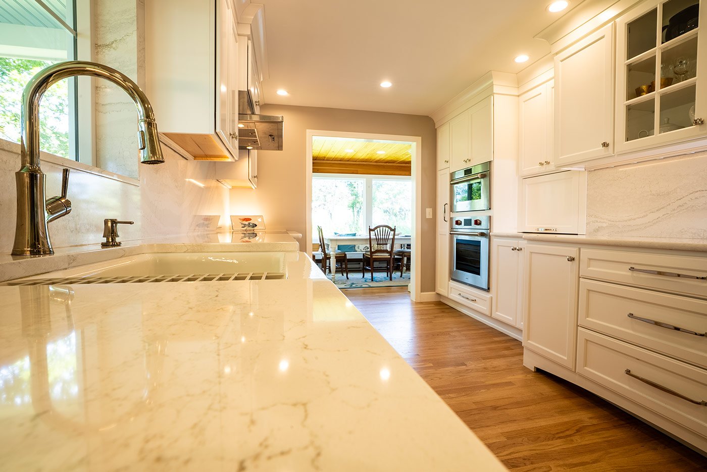Bright kitchen with marble counters and modern fixtures by Oxland Builders in New Hampshirea
