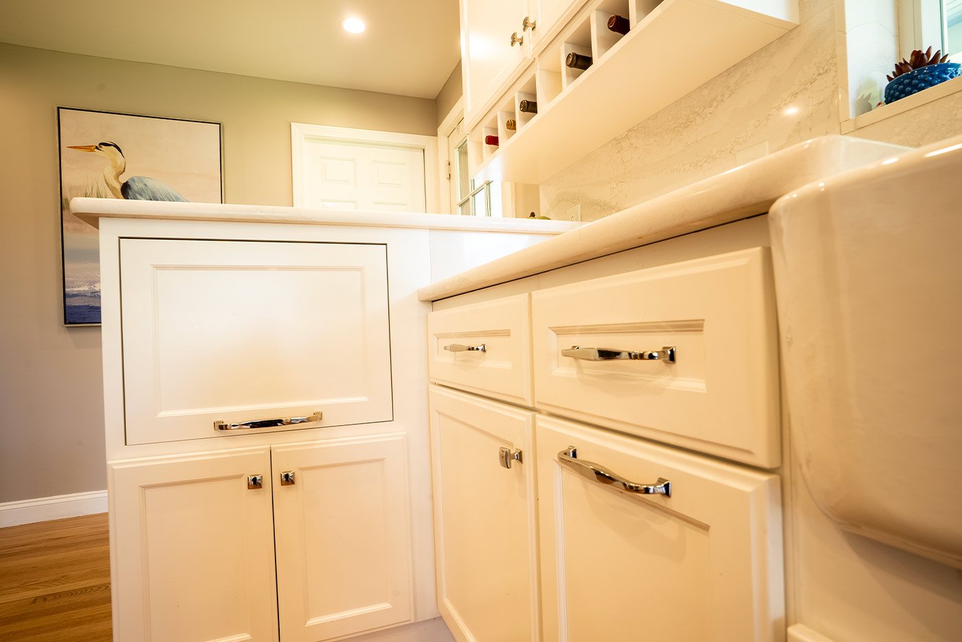 Custom drawer and cabinet storage with elegant chrome handles in a bright coastal New Hampshire kitchen