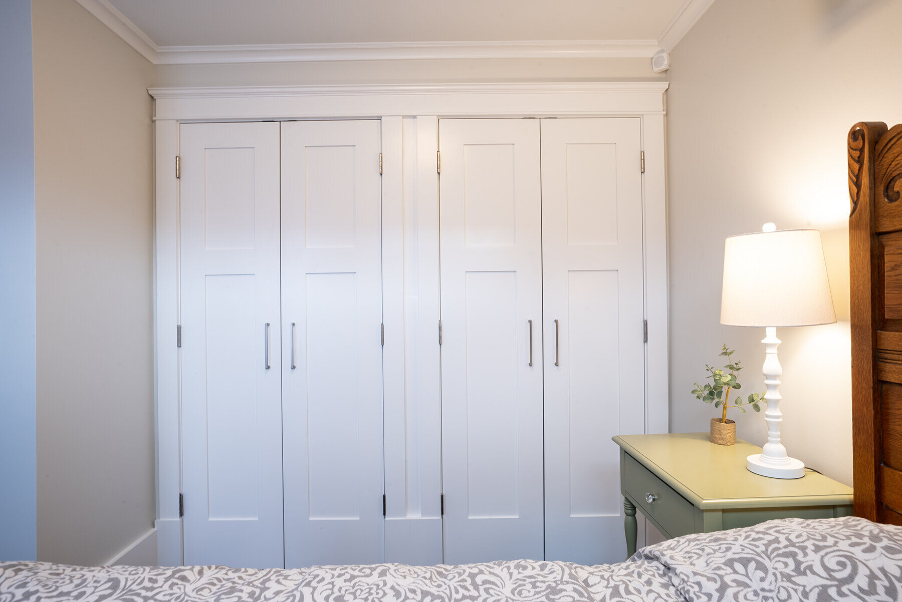 Custom-built white closet doors with sleek handles in a New Hampshire bedroom remodeled by Oxland Builders Custom-built white closet doors with sleek handles in a New Hampshire bedroom remodeled by Oxland Builders