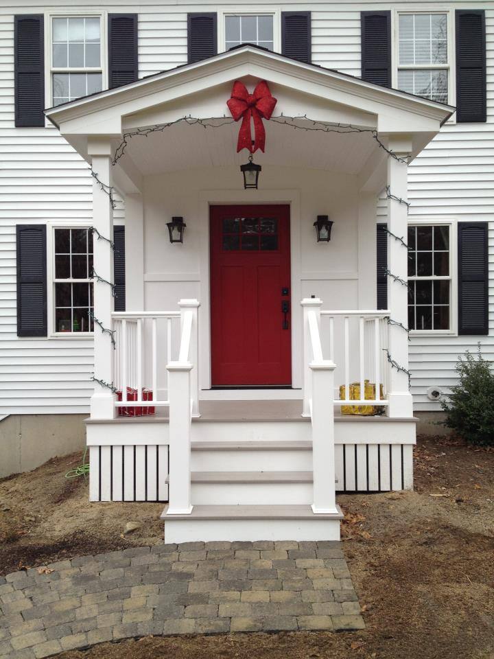 Front entrance with a red door and festive decor, designed by Oxland Builders in New Hampshire