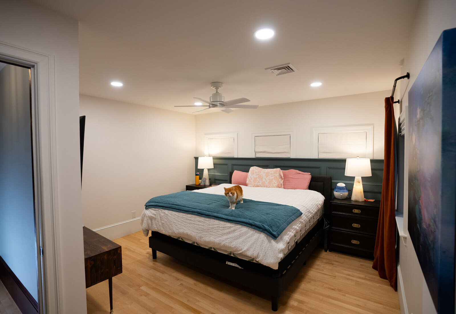 Spacious bedroom with wooden flooring and a cozy bed, a project by Oxland Builders in New Hampshire