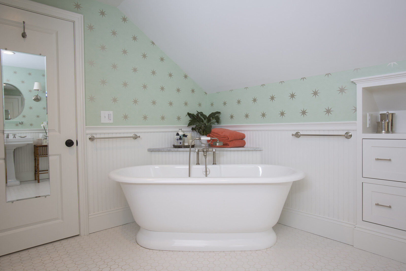 Bathroom remodel by Oxland Builders in New Hampshire featuring a standalone tub and star-patterned wallpaper