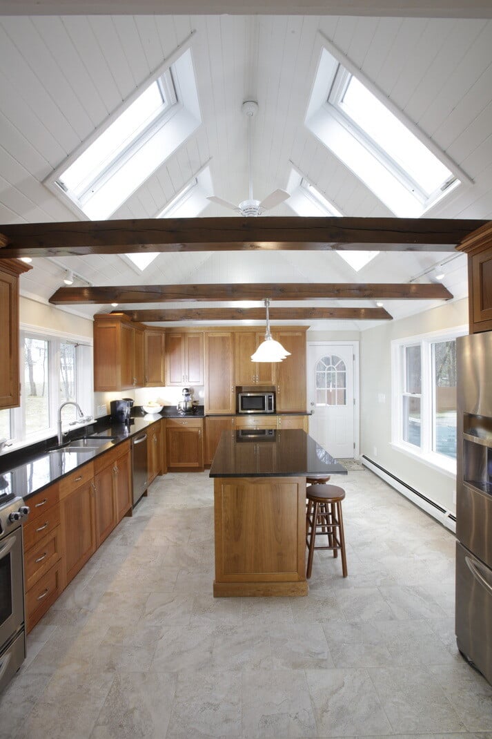 A kitchen remodel in New Hampshire by Oxland Builders with a mix of natural wood tones and bright skylights