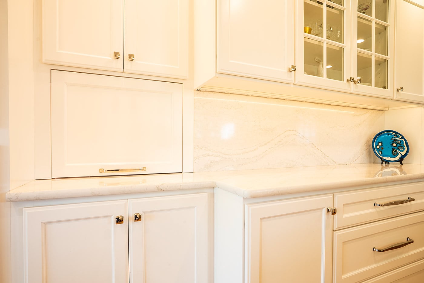 Seamless built-in cabinetry with clean white finishes and glass-front uppers in a coastal New Hampshire home Seamless built-in cabinetry with clean white finishes and glass-front uppers in a coastal New Hampshire home